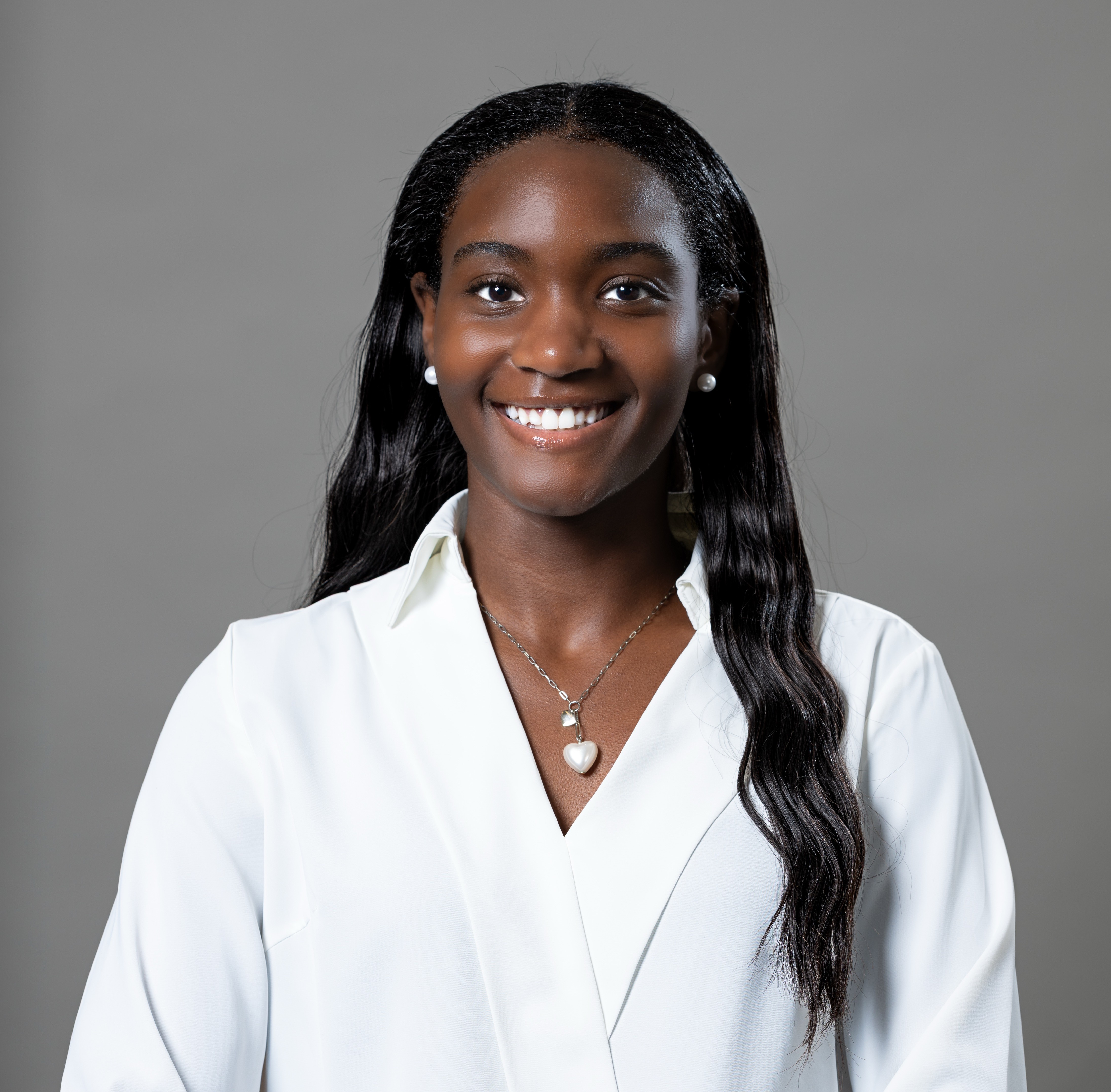 A headshot of Alyssa Hawkins wearing a white lab coat and smiling